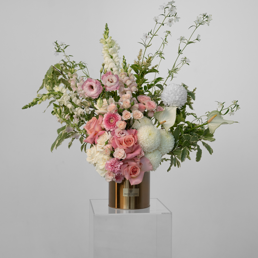 Floral arrangement with pink and white flowers in a vase on a gray background