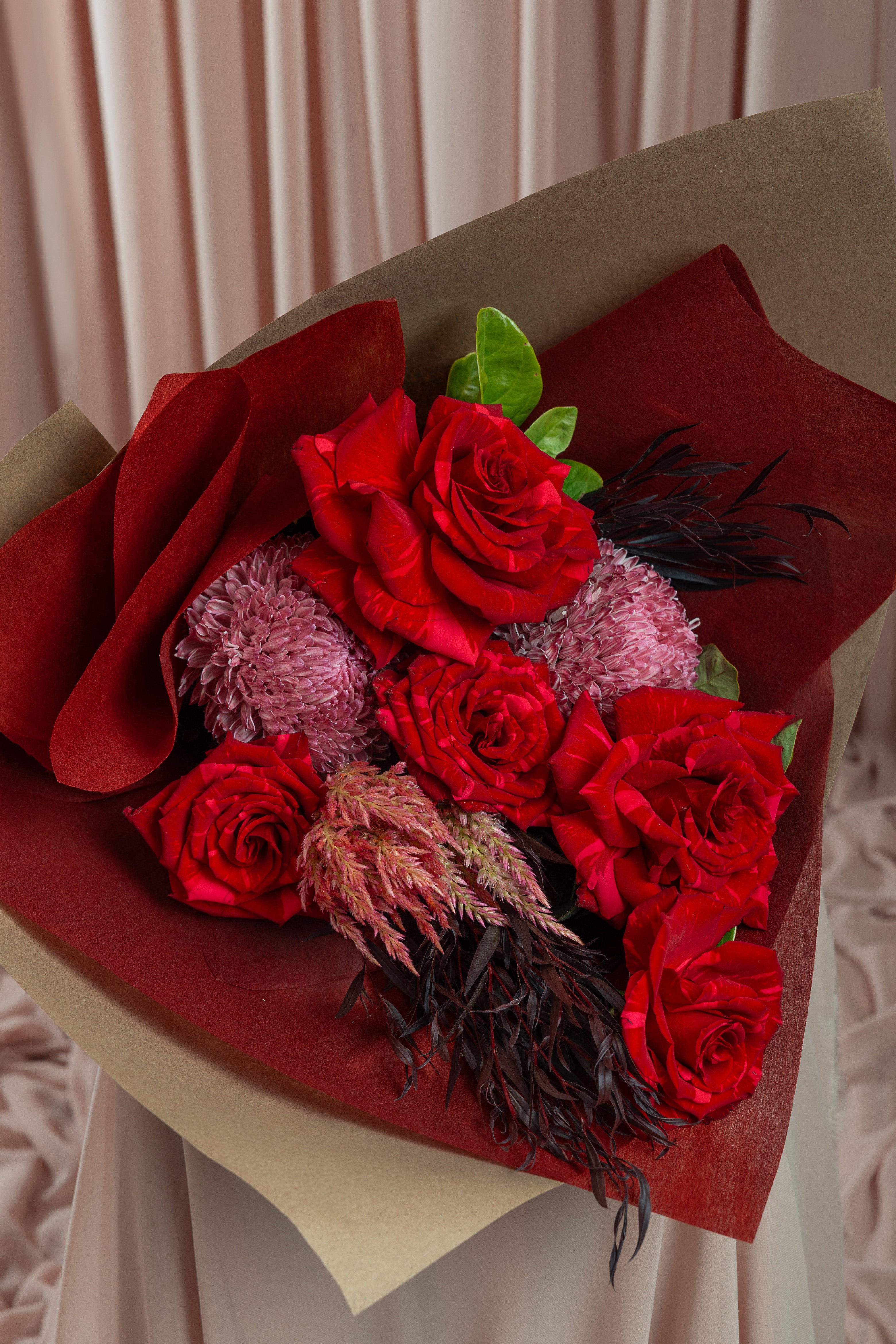 Close-up red rose bouquet with textured foliage by Maison Bloomé Adelaide florist