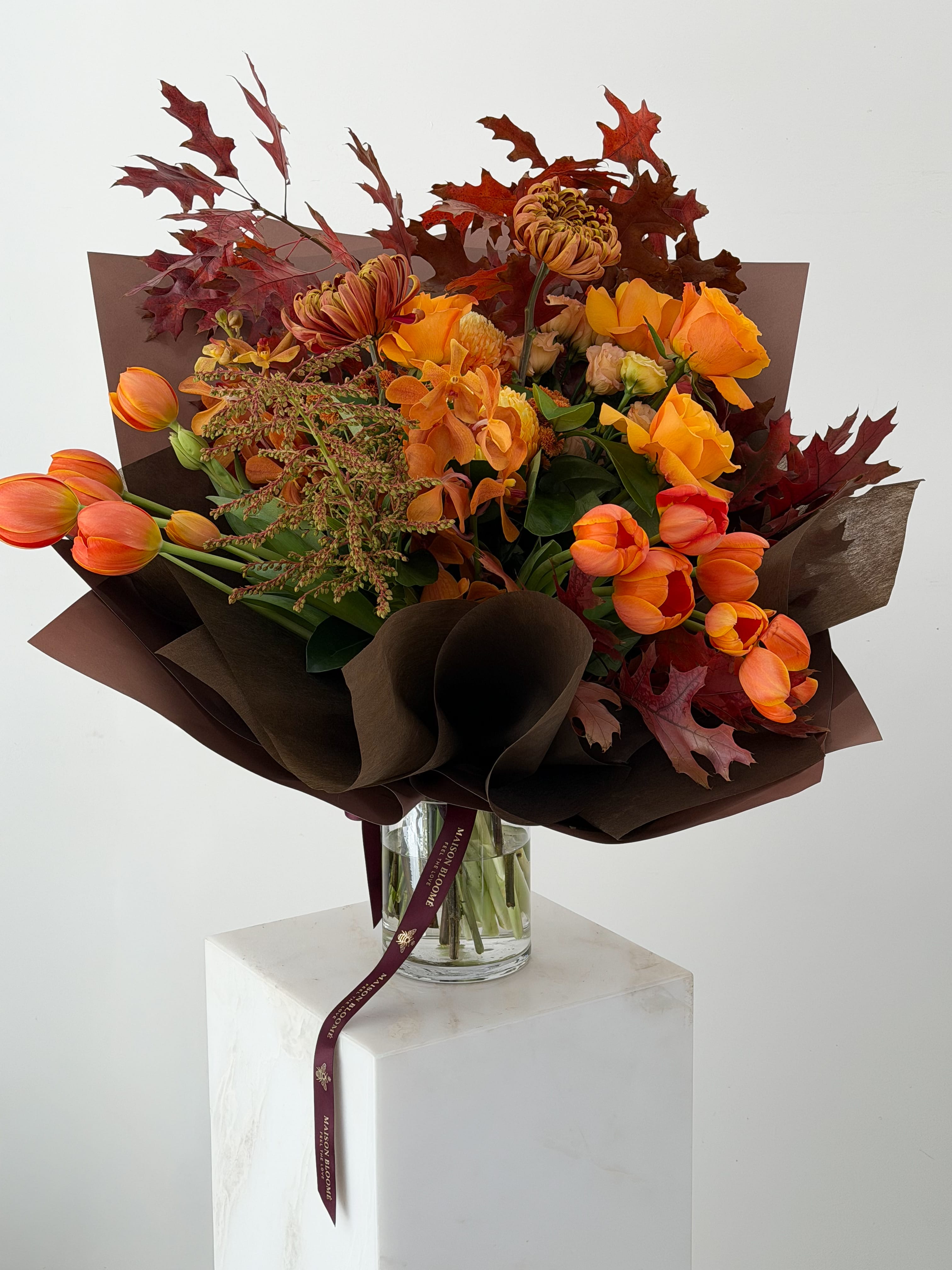 Editorial autumn bouquet in burnt orange and deep burgundy tones featuring tulips, orchids, roses and seasonal foliage by Maison Bloomé Adelaide.