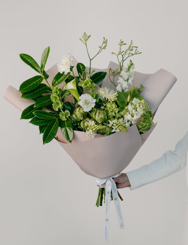 Green and white flower bouquet with fresh greenery wrapped in paper by Maison Bloomé florist Adelaide with same day delivery